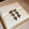 Macro shot of triple golden heart earrings with black micro-inlaid stones on white leather - Triple Black Heart Style (21#银针-暗金色)