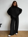 Detail of black knitted two-piece set featuring a high-neck sweater and wide-leg trousers - S / Black