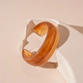 Macro view of wide chunky amber resin cuff bracelet with marble texture on minimalist stand - Coffee Open Cuff (74#)