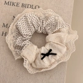 Detailed shot of beige lace scrunchie with polka dots and black ribbon bow hair accessory - Cream Patchwork Lace
