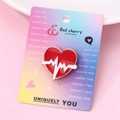 Detailed close-up of a red heart enamel brooch with white heartbeat line on display card - Red ECG Heart