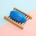Blue oval handmade soap on a natural rectangular wooden soap dish with a smooth finish - 110g Thai-style Floral Scented Soap