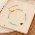 Böhmisches Perlenarmband mit mintgrünem Herzanhänger auf rustikalem Steinuntergrund - Malachitgrün/4# Malachit