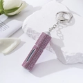 Detail of pink rhinestone portable perfume atomizer keychain on a white marble stone - Pink