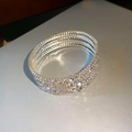 Detailopname van meerlaagse zilveren armband met glanzende strass en bloemaccenten - 6# Drievoudige zilveren gekruiste armband
