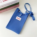 Dettaglio di una borsa a tracolla in maglia blu con etichetta Hildi su sfondo bianco - 12*20cm / Blu Chiaro