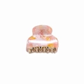Detailed close-up of a pink and yellow marbled acetate hair claw with gold metal teeth - Sunstone