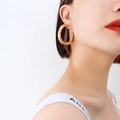 French style twisted hollow hoop earrings in 18k gold plated titanium steel on model - Medium Version / Gold