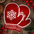 Sacchetto regalo di Natale rosso a forma di guanto con fiocchi su sfondo di legno - Muffole di Natale