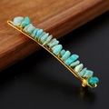 Detailed macro view of sky blue crystal stones handcrafted on a golden hair clip - Amazonite + Gold Clip