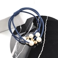 Détail d'élastiques à cheveux bleu marine avec perles blanches et billes dorées - Bleu clair