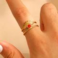 Detailed macro of gold double-band ring with sunburst motif and red gemstone accent - 18k Gold Plated (4905)