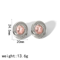 Detailed close-up of silver-tone stud earrings with pink zircon and spiral textured edges - Pink Gemstone Silver Style (TE6781-PK-S)