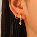 Elegant gold asymmetric eight-point star earrings with zircon inlay worn by model - Octagonal Star Pendant Earrings (4492)