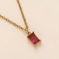 Macro shot of rectangular red zircon pendant on gold-plated 18K titanium steel chain - July/Ruby Red