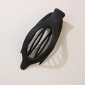 Matte black oval hair clip with leaf cutout design on a neutral background - Matte Black