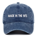 Close-up of 'MADE IN THE 90'S' white embroidery on washed navy cotton baseball cap - Navy Blue