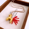 Close-up of golden horse pendant necklace with red glass bead tail on display - Matte Gold