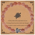 Close-up of 8mm orange beaded turtle bracelet on a decorative handmade gift card - Sunstone