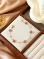 Detail of flower beaded chain bracelet with adjustable lobster clasp in 18K gold finish - Orange and Purple