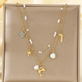 Dettaglio della collana dorata a strati con ciondoli marini su sfondo di seta - Stile Delfino Stella Marina Perla (KN292157-SXSJ)