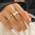 Nahaufnahme eines goldenen Ring-Sets mit glattem breitem Band und Wellendesign - Gold Breit + Dünne Welle 2er-Set