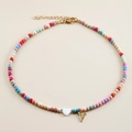 Detailed view of colorful beaded necklace with golden V pendant and white heart charm - Letter V