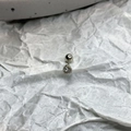 Macro shot of silver titanium steel ear stud with clear zircon and screw back closure - White
