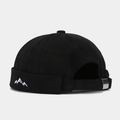 Detail of mountain embroidery and adjustable metal buckle on a black docker cap - Black
