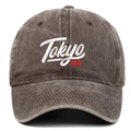 Detail of high-density Tokyo embroidery on vintage washed grey cotton baseball cap - Coffee