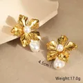 Macro shot of gold floral earrings featuring brushed metal and baroque pearl details - 18K Gold / Gold Flower Baroque Earrings