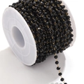 Black faceted beads with golden wire chain on a white spool for DIY jewelry making - Gold-Black