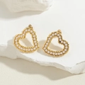 Elegant gold heart earrings with white pearls on a natural white stone background - Heart Earrings