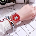Red square digital sports watch with transparent strap worn on wrist for students - Red