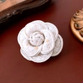 Dettaglio ravvicinato di una spilla a camelia in tweed bianco con paillettes dorate - 42# Camelia Tweed Bianco
