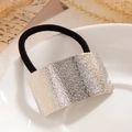 Silver hammered rectangular metal ponytail holder with black elastic hair tie on white plate - Silver - Hammered Arc