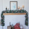 Lush flocked Christmas garland with pine cones on fireplace mantel with festive gift boxes - 2.7m Flocked Mixed Christmas Rattan