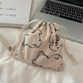 Gros plan sur un sac en velours côtelé crème avec motif d'ours et cordon de serrage - Blanc Cassé