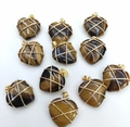 Close-up of heart-shaped tiger eye stone pendants with gold wire wrapping detail - Natural Tiger Eye