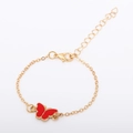 Close-up of golden adjustable chain bracelet with a vibrant red butterfly charm and lobster clasp - Red