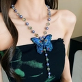 Détail du pendentif papillon brodé bleu avec perles irisées sur un collier en cordon de soie - Papillon brodé violet