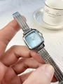 Close-up of a luxury square silver watch with light blue dial on a female wrist - Silver Band Blue Dial