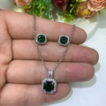 Macro shot of silver jewelry set with green emerald-cut stones and zircon accents - Emerald