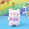 Detailopname van een roze pluche kattenhanger met een kanten rok en geborduurd tekst - Kogelkettingstijl / Roze