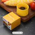 Pelador de maíz amarillo manual con hoja de metal sobre tabla de madera y caja - Envase tipo caja / Amarillo