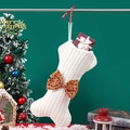 White bone-shaped knitted Christmas stocking with a brown polka dot bow decoration - Knitted Bone Stocking / White