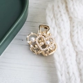 Elegante molletta per capelli a cuore dorata con perle bianche su sfondo minimalista - Stile Perla Dorata