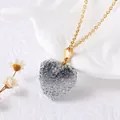 Détail du collier pendentif cœur doré avec incrustation de cristaux scintillants - Dégradé de Gris et Blanc
