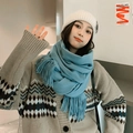 Blue cashmere-feel thick knitted scarf with fringe details worn by a female model - Balsam Green