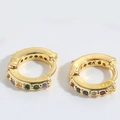 Close-up of gold huggie hoop earrings with multi-color zircon stones on white background - Colorful